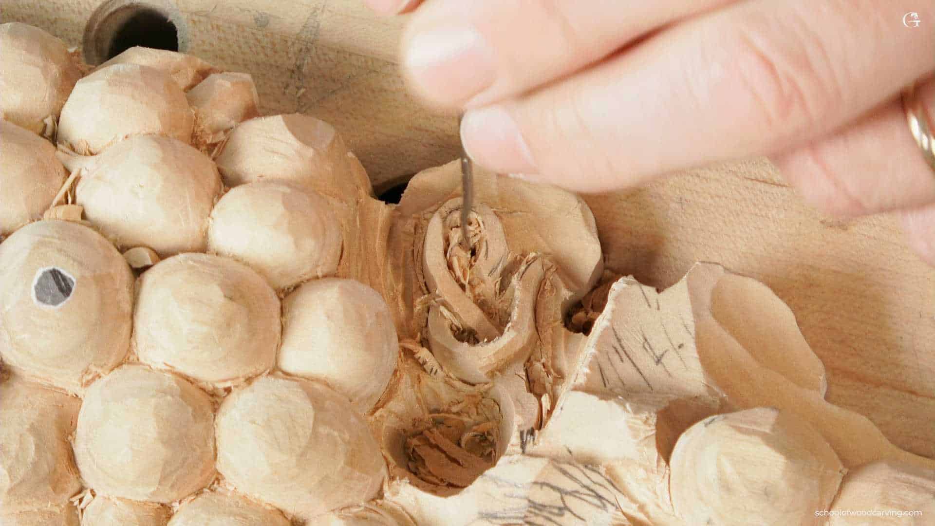 WOODCARVING LESSONS: Close-up shot of Woodcarver Grabovetskiy carving a detailed pattern on wood. He holds a small chisel, perfecting the fine details on the wooden piece. - Wood Carving tutorials