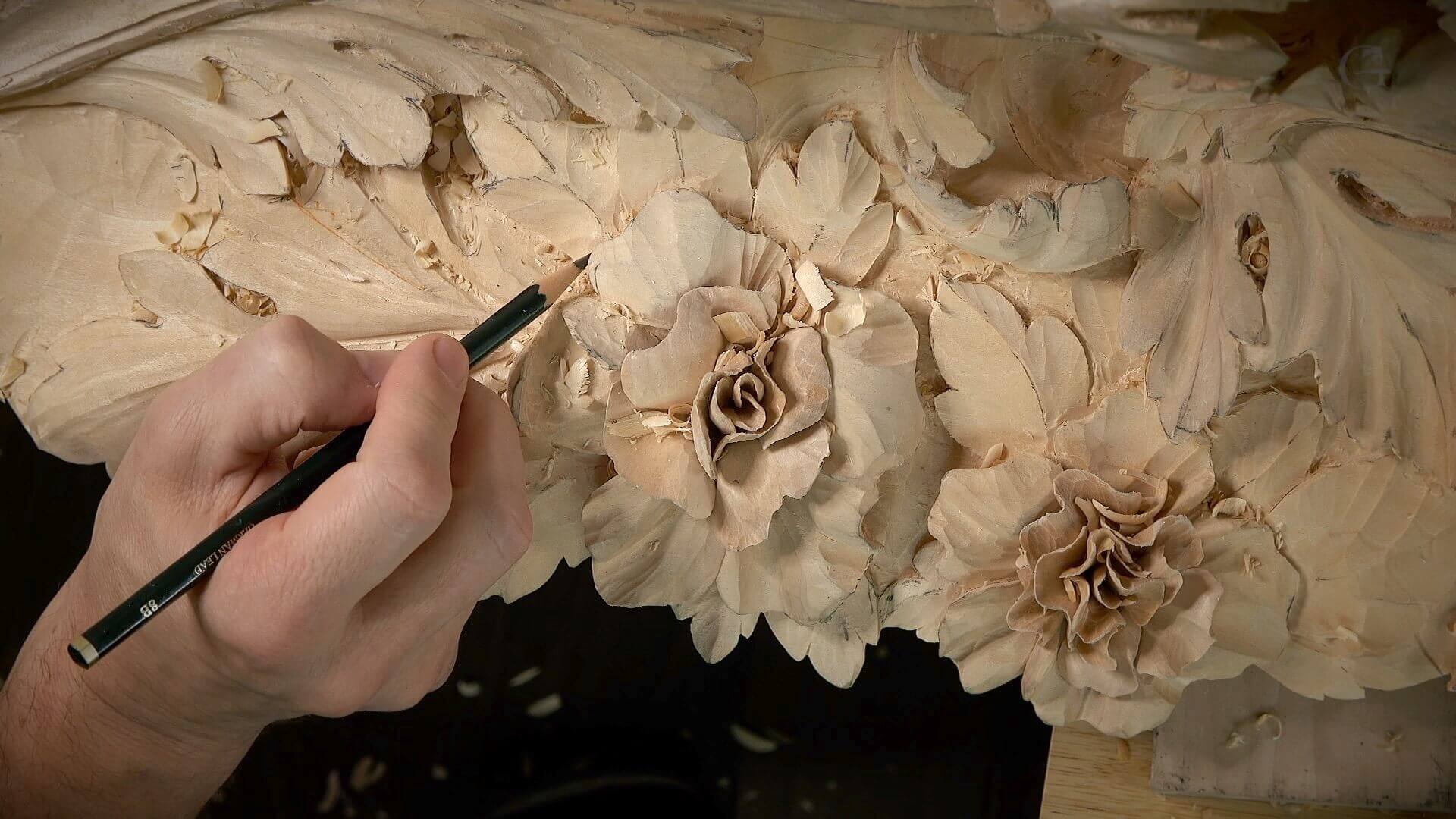 A skilled wood carver is focused on detailing intricate floral patterns on a wooden piece. The carver's hand grips a pencil, expertly marking where to make cuts. This image perfectly captures the essence of wood carving—patience, precision, and plenty of creativity!!! If you’re thinking about taking wood carving classes or lessons, this could inspire you to dive right in! Happy carving!